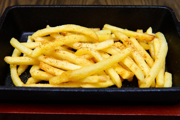 French Fries With Cheese Powder in Black bowl