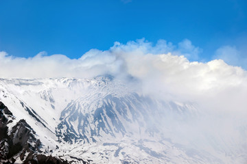 smoke around mount etna crater in winter