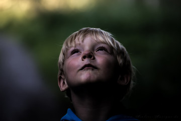 blonder Junge besinnt sich im Wald