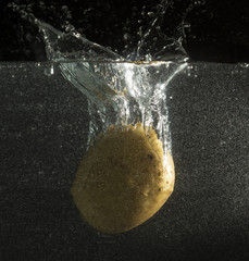 Turnip in water with splashes on a black background