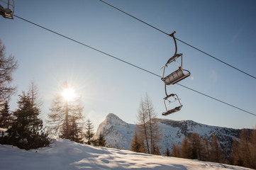 chair lifts with snow-capped dolomites in the background