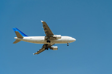 Fototapeta na wymiar Passenger Airplane Flying On Clear Blue Sky
