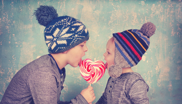 zwei Kinder teilen einen Lollipop