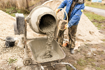 worker pours concrete mortar on a construction site