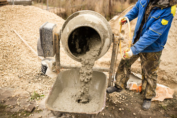 worker pours concrete mortar on a construction site