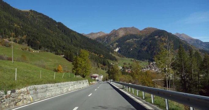 Mountain road, Cinema 4k view driving on a alpine road, through little Airolo town, on a sunny autumn day, near gotthard pass, in the swiss alps, in Ticino, Switzerland