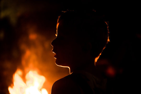 Junge h&ouml;rt gebannt den Geschichten am Lagerfeuer zu