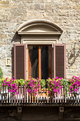 Fototapeta na wymiar Brick house with flowers and balcony in Florence, Italy