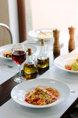 Italian traditional pasta with tomatoes and seafood on restaurant table.
