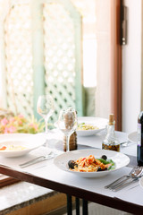 Table at italian restaurant served with traditional spaghetti pasta.