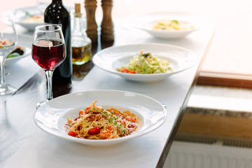 Table at italian restaurant served with traditional spaghetti pasta.