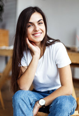 Portrait of young beautiful girl wears white t-shirt sitting on wooden chair indoor
