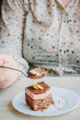 Woman eating small cake in a restaurant.