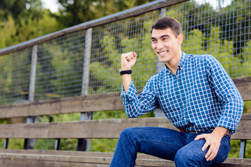 Obraz premium Young man sitting at the stadium rejoices for your favorite team. Emotional face. Copy space