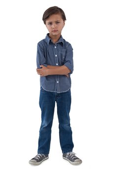 Boy standing with arms crossed against white background