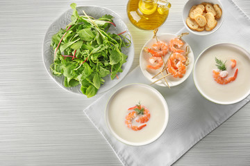 Composition with yummy shrimp cream soup on wooden table, top view
