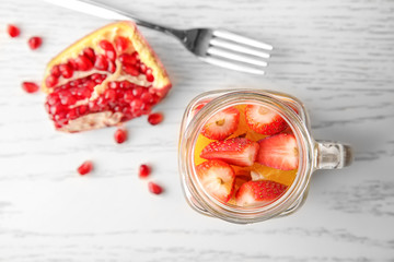 Delicious fruit salad in mason jar on table