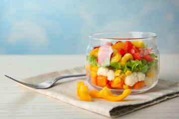 Delicious vegetable salad in jar on table