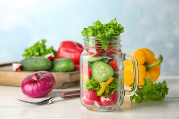 Delicious vegetable salad in jar on table