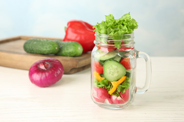 Delicious vegetable salad in jar on table