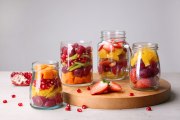 Fototapeta na wymiar Glassware with delicious fruit salads on table