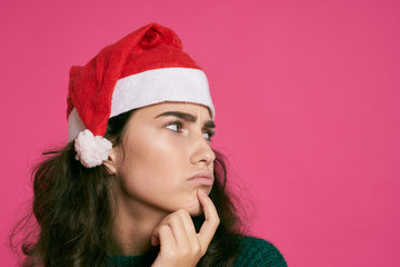 woman in a Christmas hat, portrait, light pink background