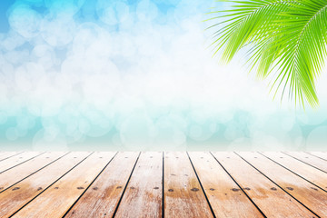 Empty wooden table and palm leaves with party on beach holidays blurred background in summer time.  