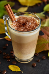 Warm, spicy drink - latte with cinnamon and pumpkin on a black background