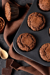 Chocolate muffins, brownies with nuts and chocolate on a black background