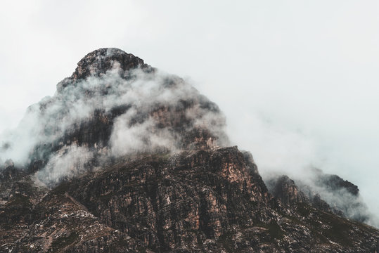 Fog shrouded rugged mountain peak and landscape