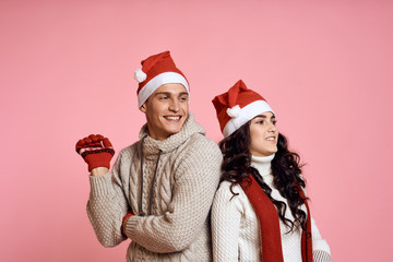 Couple smiling on a light pink background, new year, winter