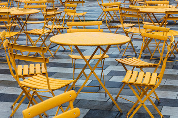 tables and chairs in a cafe on street
