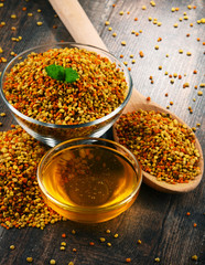 Bowls with bee pollen and honey on kitchen table