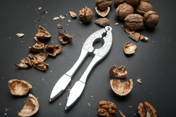 The process of opening the core of the walnut and whole walnuts on a black background.