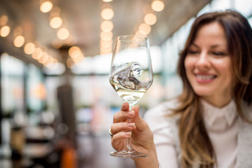 Closeup of woman holding glass of wine in cafe restaurant.