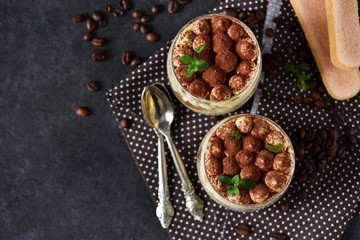 Classic tiramisu in a glass jar on the background chermon