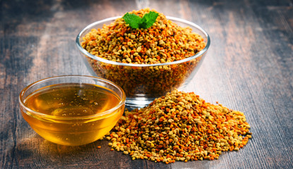 Bowls with bee pollen and honey on kitchen table