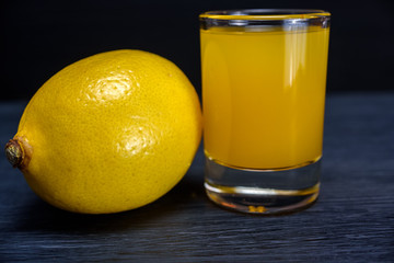 Lemon and lemon juice on a dark wooden background
