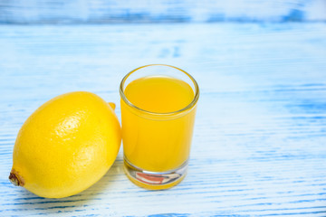 lemon and lemon juice on a light wooden background  
