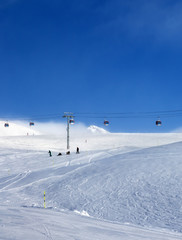 Fototapeta na wymiar Gondola lift and snowy ski slope in fog