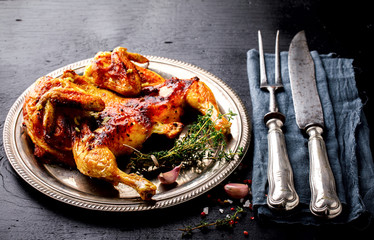 Grilled fried roast Chicken Tabaka with thyme and garlic, in Frying pan on wooden Background.Festive dish.