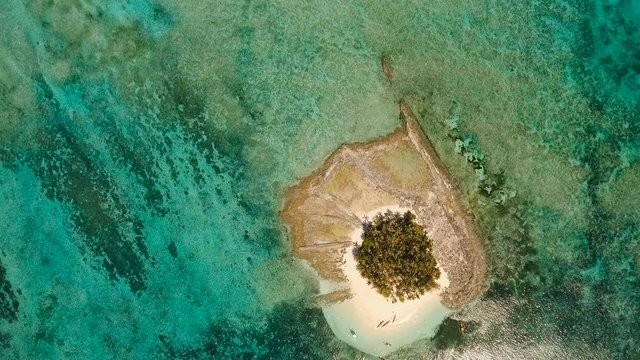 Aerial view of beautiful tropical island Guyam with white sand beach. View of a nice tropical beach from the air. Seascape: Ocean and beautiful beach paradise. Philippines. 4K video. Travel concept