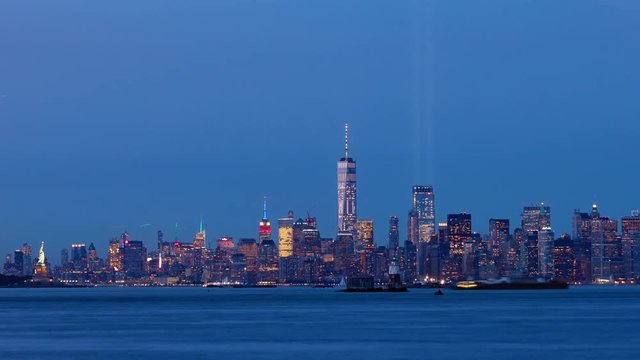 Timelapse of Lower Manhattan at dusk with the two beams of lights from the Tribute in Light coming on. New York City Harbor