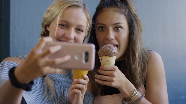 Girls with ice cream cones posing for cell phone selfie for social media / Provo, Utah, United States