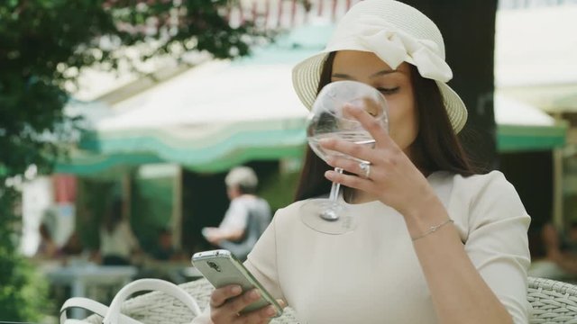 Close up of woman texting on cell phone at cafe outdoors / Kazanluk, Bulgaria