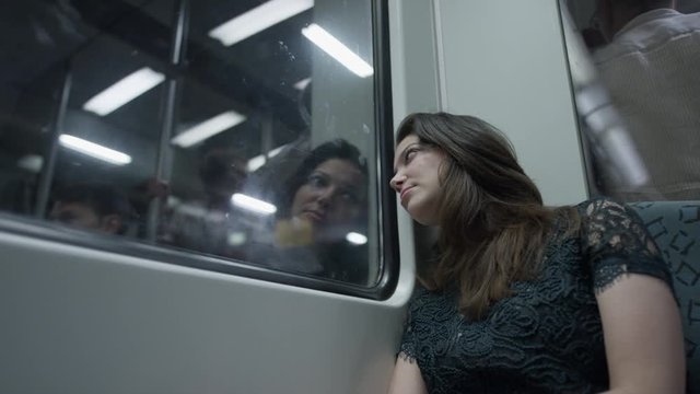 Medium low angle shot of bored woman leaning on window in train / Berlin, Germany