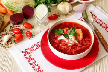 Traditional Ukranian soup borsch on a white napkin embroidered in Ukrainian style.