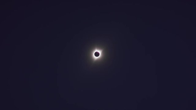 Distant total solar eclipse changing to reveal bright lens flare / Driggs, Idaho, United States