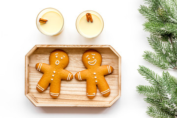 Eggnog for christmas evening. Two glasses near gignerbread cookie and spruce branch on white background top view
