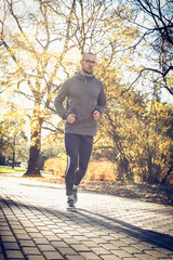 Fototapeta premium Young man run trough public park.